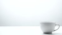 White ceramic coffee cup on clean surface against minimalist background for morning beverage concepts and kitchen design projects.