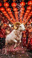 Festive white goat with golden horns celebrates among red lanterns and falling confetti with people in traditional red clothing during lunar new year celebration.