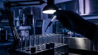 Scientist conducting research experiments with test tubes in modern laboratory under blue lighting for medical and scientific studies.