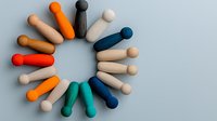 Colorful wooden figures arranged in circle formation on gray background showing unity, diversity and teamwork concept for business presentations and social media.