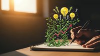Hand drawing creative lightbulb tree with green leaves on notebook, symbolizing innovation, growth, brainstorming and sustainable business development concepts.