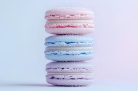 Delicate French macarons in pastel pink and blue stacked vertically on light background, showcasing soft meringue texture and creamy filling for patisserie marketing.