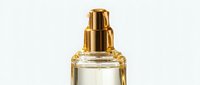 Luxury fragrance bottle with golden metallic pump dispenser and clear liquid perfume against white background for cosmetics and beauty branding.