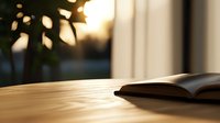 Open book on wooden table with soft natural sunlight and blurred plant silhouette creating peaceful morning atmosphere, suitable for education and lifestyle designs.