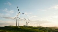 Wind turbines on green rolling hills at sunset, generating renewable clean energy for sustainable power production and environmental conservation.