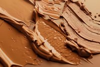 Creamy foundation makeup smears and swatches in various nude and brown tones showing rich texture and cosmetic product consistency. Perfect for beauty content.