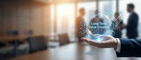 Long term value creation concept with businessman holding glowing digital globe in modern office environment with colleagues in background.