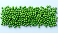 Fresh green peas scattered in rectangular shape on light blue background, top view. Natural organic vegetables pattern for healthy eating concept.