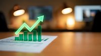 Green holographic growth chart with upward arrow emerging from business report on office desk, representing financial success and data analytics.