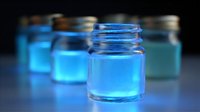 Glowing blue liquid in glass jars creates mysterious scientific atmosphere with neon illumination against dark background, suitable for technology and research concepts.