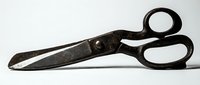 Vintage black metal scissors with worn patina isolated on white background, ready for design projects, crafts, and educational materials.