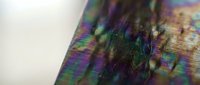 Iridescent holographic foil surface with rainbow colors creating abstract metallic texture for modern design projects and creative backgrounds.