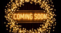 Glowing neon coming soon sign with warm golden bokeh lights creating anticipation for business opening or product launch announcement.