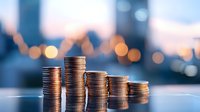 Stacks of coins arranged in descending order against blurred city lights background showing financial decline and investment concept for business analysis.
