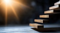 Wooden blocks arranged as ascending stairs with dramatic lighting and shallow depth of field, symbolizing growth, progress and achievement in business.