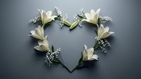 White lilies and baby's breath arranged in a heart shape on a gray background, symbolizing love, purity, and elegance for wedding or memorial use.