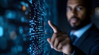 African American businessman analyzing digital data visualization on futuristic transparent screen, pointing at glowing blue statistics and charts in dark office.