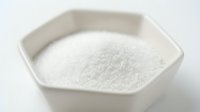 White granulated sugar in ceramic bowl, ingredient for baking, cooking, and food preparation.