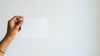 Female hand holding blank white card against neutral background, suitable for business presentations, marketing mockups, and promotional designs.