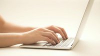 Female hands typing on modern laptop computer keyboard in bright natural light for remote work and digital productivity.