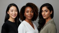 Three diverse professional women smiling confidently in business attire against neutral background for corporate marketing and workplace diversity campaigns.