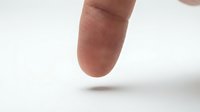 Close-up of human finger with detailed skin texture and fingerprint ridges visible against clean white background for medical or identification concepts.