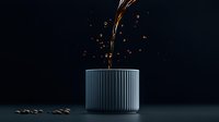 Liquid coffee stream pouring into modern gray ribbed ceramic cup against dark background with splashing drops and coffee beans scattered around.