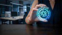 Unrecognizable person holding glowing holographic gear icon with digital interface in modern office workspace for technology and innovation concepts.