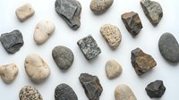 Collection of natural rock and mineral specimens arranged on white background for geology education and scientific study purposes.