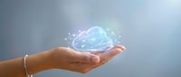 Human hand holding glowing digital cloud with network connections and data particles floating above palm representing cloud computing technology solutions.