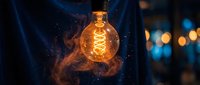Glowing incandescent bulb with warm orange light and sparkling particles, held against dark blue background with bokeh lights, symbolizing innovation and creative ideas.