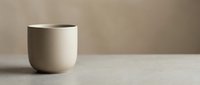 Minimalist ceramic cup with metallic rim on neutral surface, suitable for product mockups, home decor, and tableware design projects.