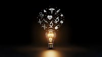 Glowing light bulb with medical healthcare icons floating above on dark background representing innovation and ideas in medicine.