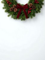 Festive wreath with burgundy velvet bow, evergreen branches, pinecones, and red berries on white background. Perfect for holiday greeting cards and seasonal marketing materials.