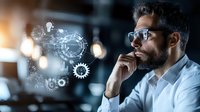 Middle Eastern businessman with beard and glasses contemplating next to floating digital gears and technology interface, representing innovation and strategic thinking.