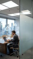 Professional businessman working on laptop in modern glass office with city skyline view and digital cloud computing icons overlay for technology concepts.