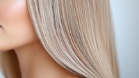 Close-up of woman's healthy straight blonde hair with natural highlights showing smooth texture and shine for beauty and haircare concepts.