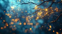 Glowing fairy lights wrapped around bare tree branches against dark blue bokeh background create magical winter evening atmosphere for holiday designs.