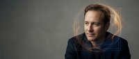 Middle-aged Caucasian male professional wearing dark blue casual shirt against neutral gray background, suitable for corporate portraits, business websites, and professional headshots.