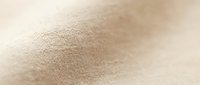 Natural beige linen fabric texture with soft focus and warm lighting creates elegant background for textile and interior design projects.