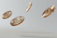 Golden bitcoin coins floating in air against light background, captured in motion with shallow depth of field, showing cryptocurrency dynamics.