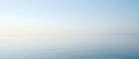 Serene misty seascape with calm waters and soft horizon, suitable for backgrounds, wellness, meditation, and tranquil design projects.