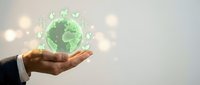 Businessman hand holding glowing green globe with leaf icons, representing sustainable business, environmental responsibility, and eco-friendly global solutions.