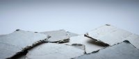 Cracked and peeling white paint on wall surface showing weathered texture and aging damage for renovation and repair projects.