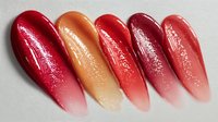 Glossy lipstick swatches in gradient shades from deep red to peach, showcasing color variety for makeup artists and beauty content creators.