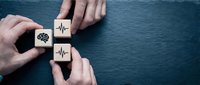 Healthcare professional arranging wooden blocks with heartbeat and pulse symbols, representing medical diagnosis, cardiology services, and health monitoring solutions for hospital and clinic use.