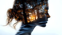 Double exposure portrait of a woman with long hair in profile, featuring a forest landscape and flowing water integrated within her silhouette at sunset.