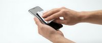 Close-up of hands holding and using a smartphone with blank screen, isolated on white background for app mockup and technology design projects.