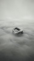 Smooth stone with oval opening partially submerged in flowing water, creating ripple patterns. Monochromatic landscape suitable for fine art, meditation, and conceptual design projects.