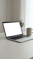 Modern laptop with blank white screen on clean desk workspace with coffee mug and plant for remote work presentations and business mockups.